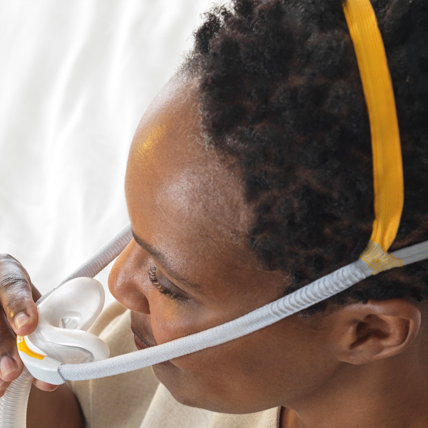 Person using a CPAP mask with a white background