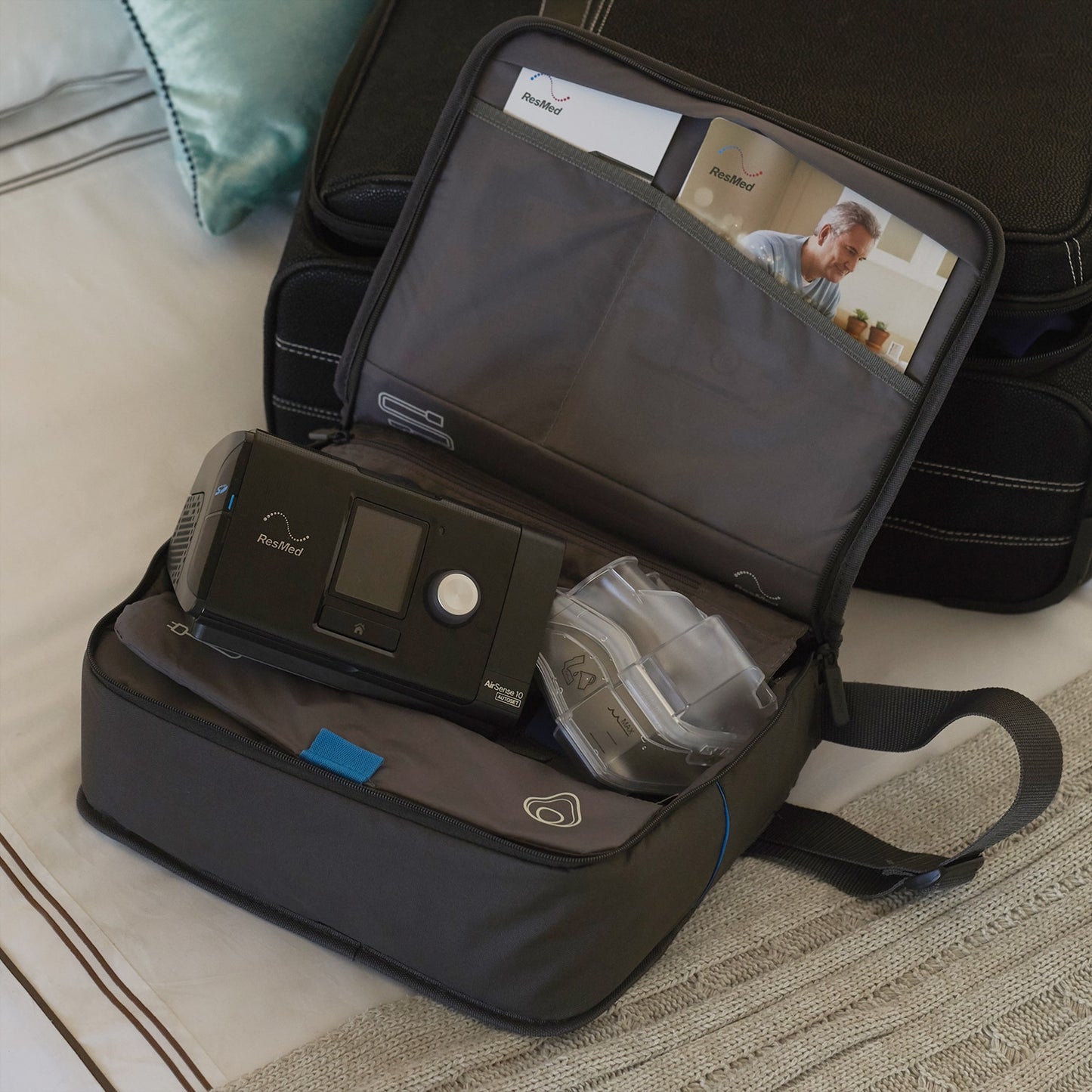 Portable oxygen concentrator in a travel bag on a bed