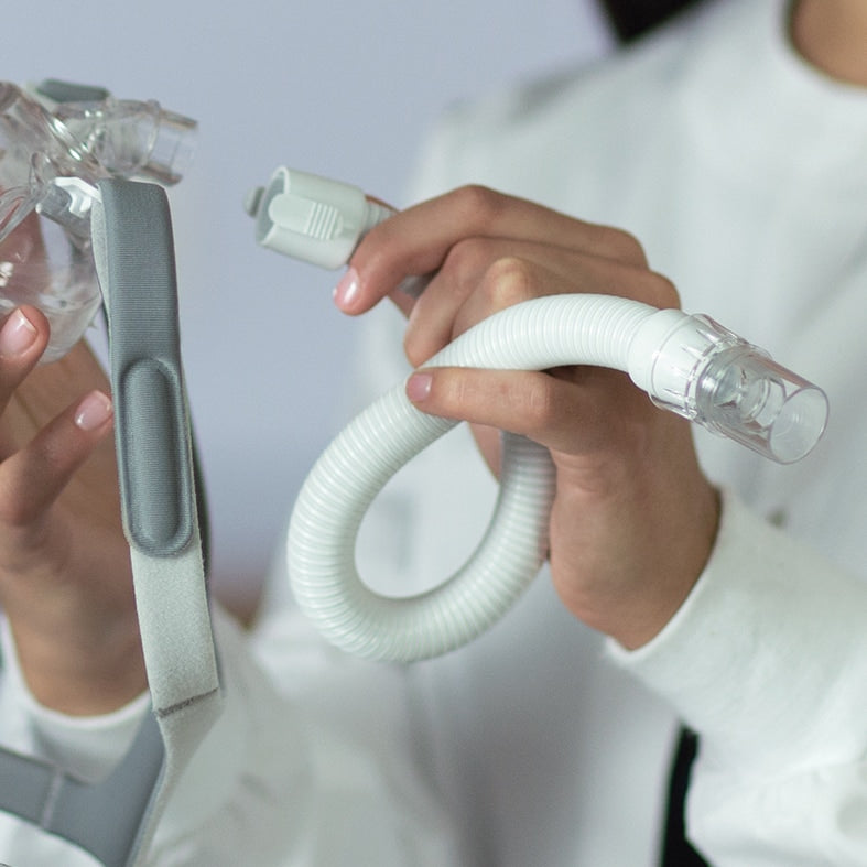 Hands Holding an Amara View Mask and Short Tube with Swivel