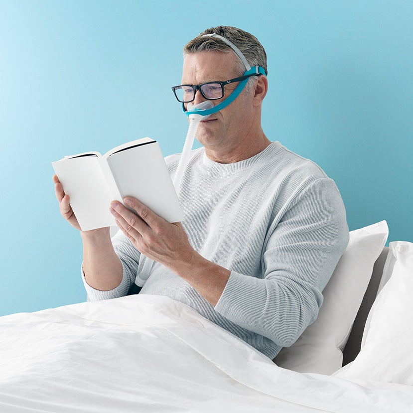 Man Reading in Bed with an Evora Nasl Mask On