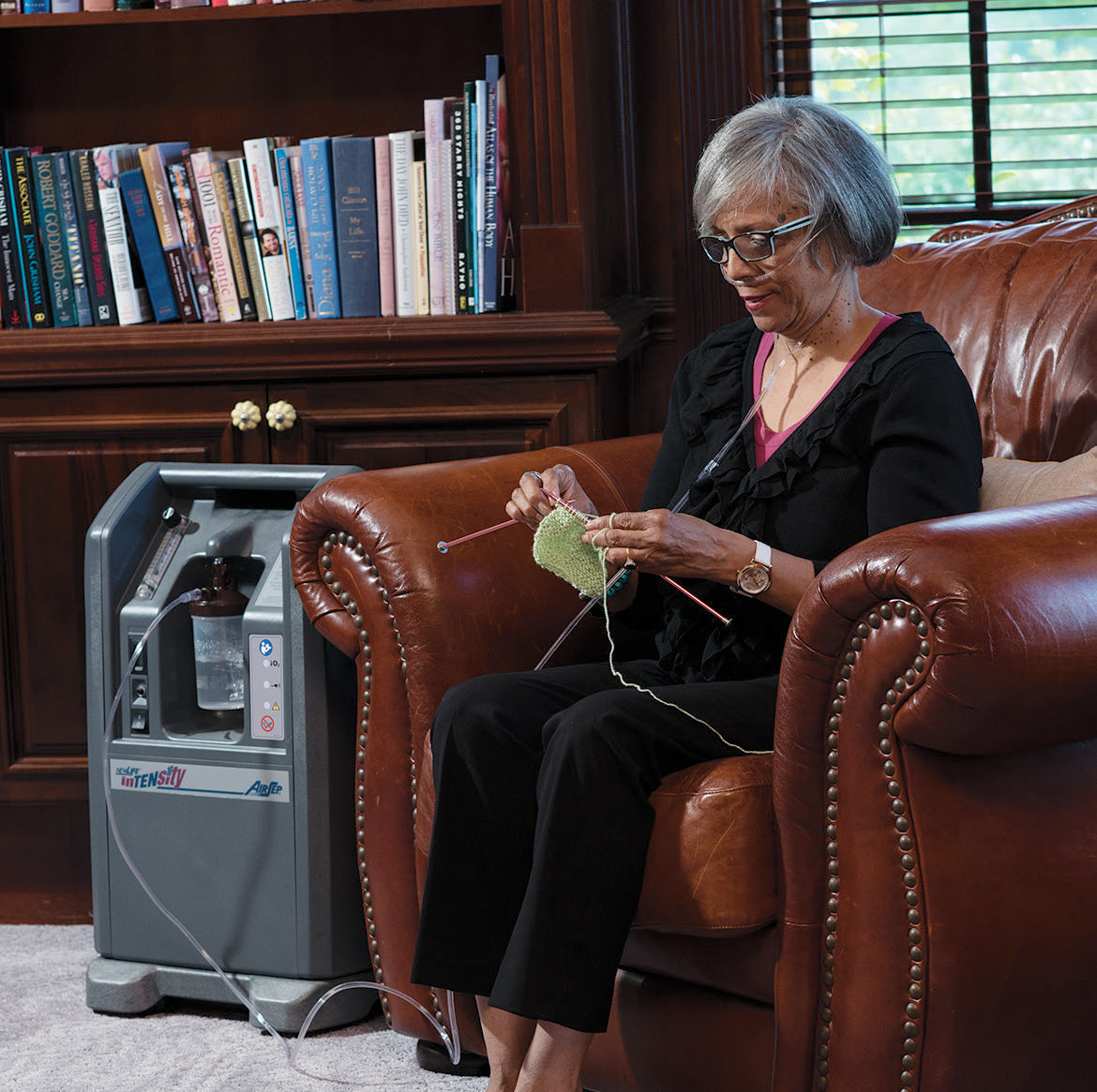 Woman Sitting On a Chair using Newlife Intensity 10 Oxygen Concentrator