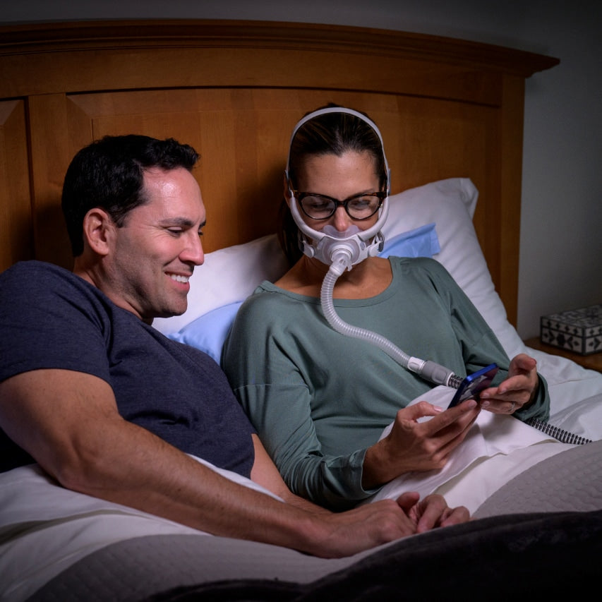 Couple Awake in Bed with Woman Wearing AirFit F40 CPAP Mask