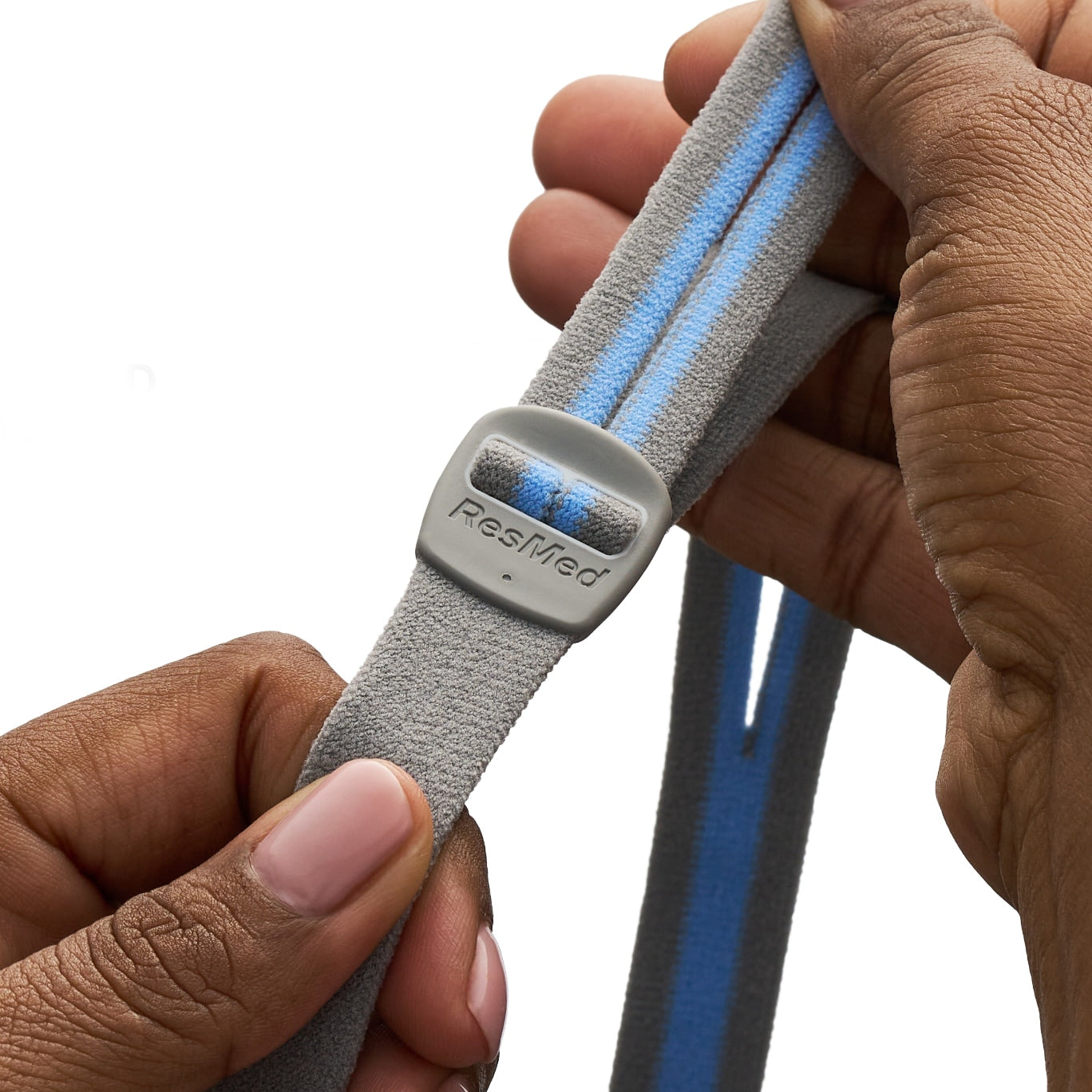 Gray strap with blue accents held by a hand, featuring the ResMed logo.