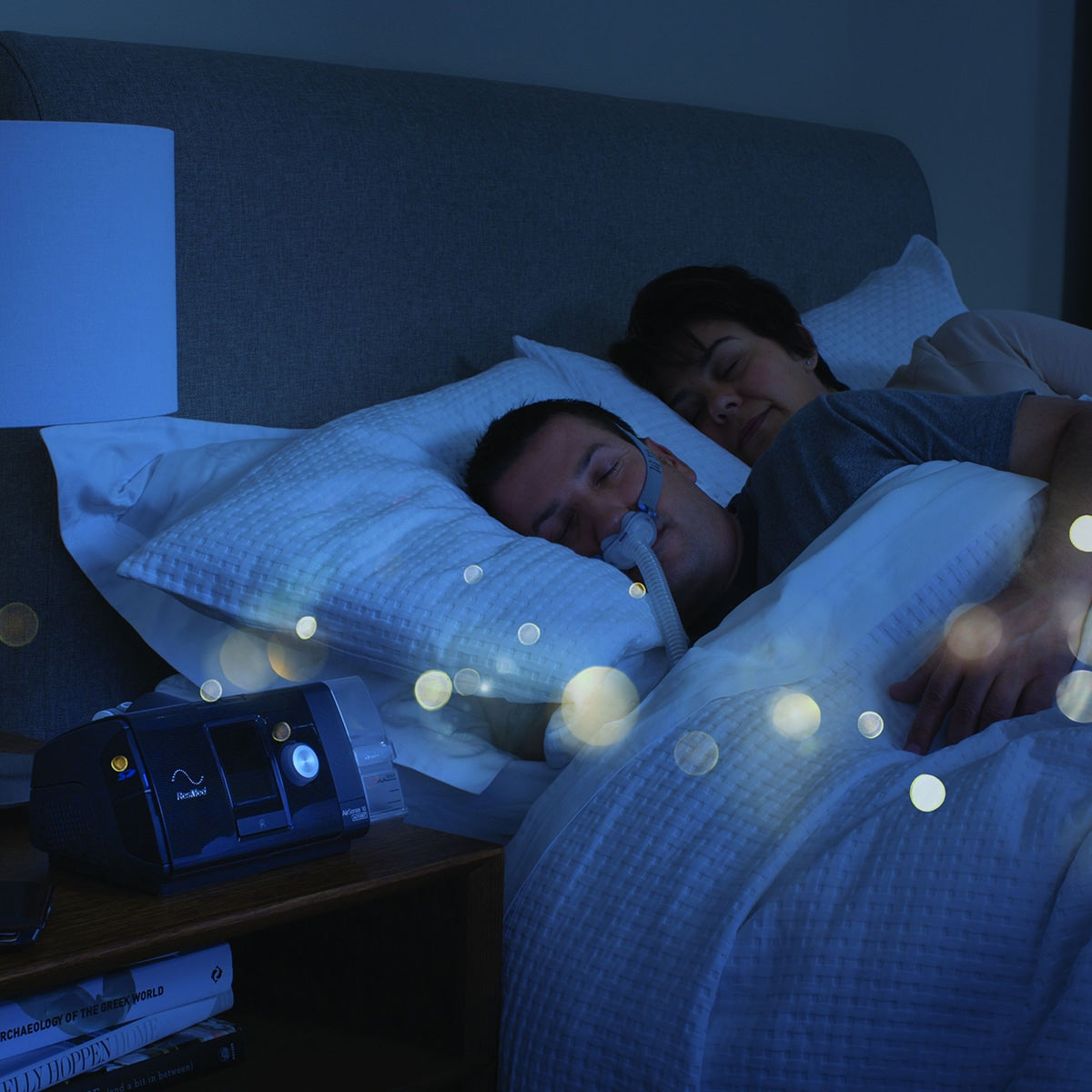 man sleeping in bed using an airsense 10 cpap machine