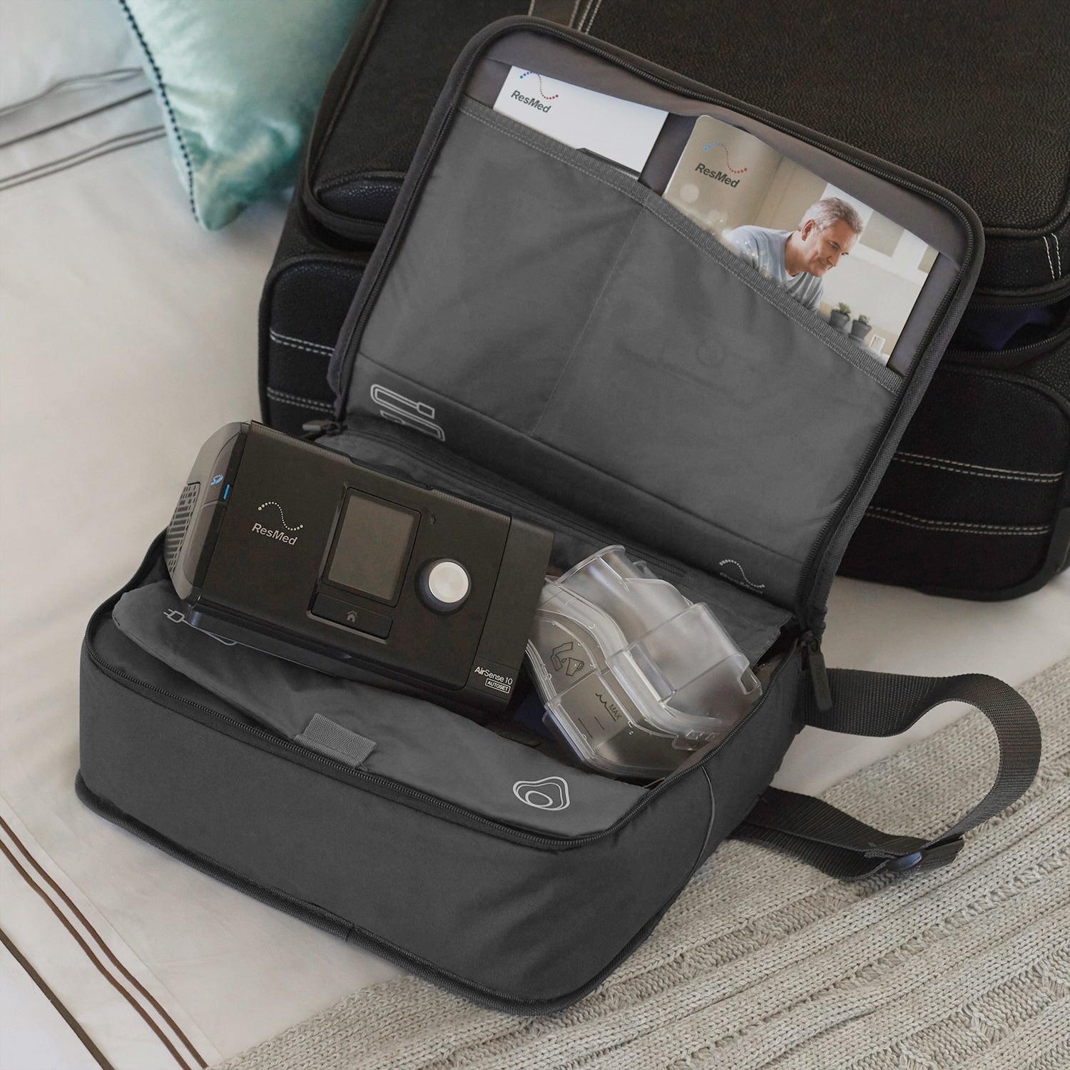 Resmed AirSense 10 CPAP in a travel bag on a bed