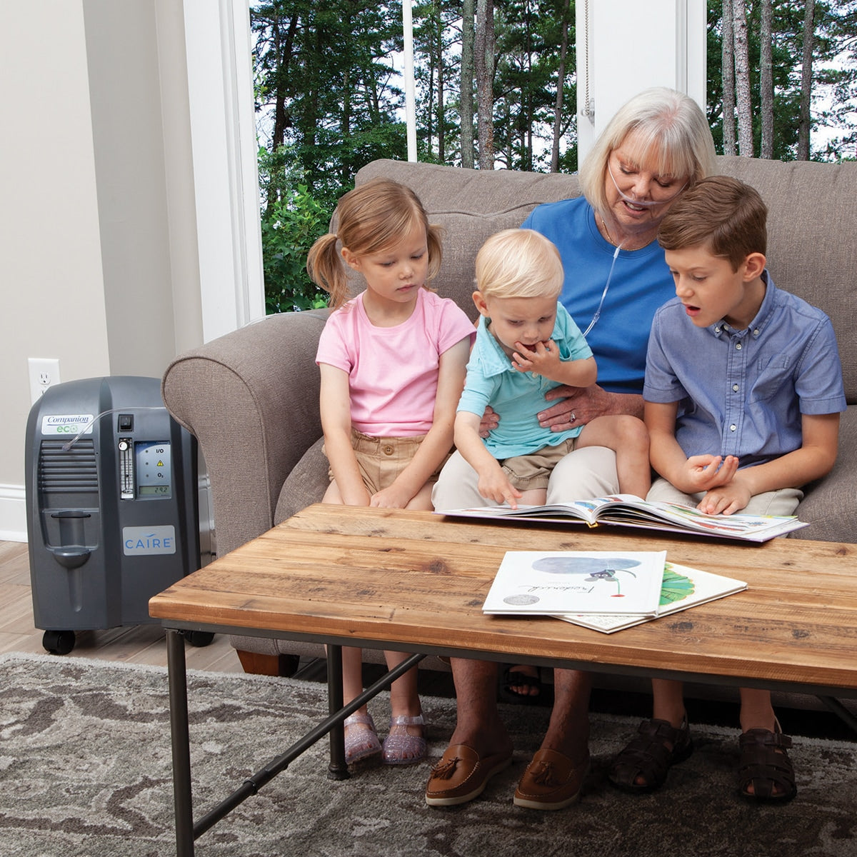 Woman sitting on couch with three children while wearing Companion 5 ECO Concentrator 