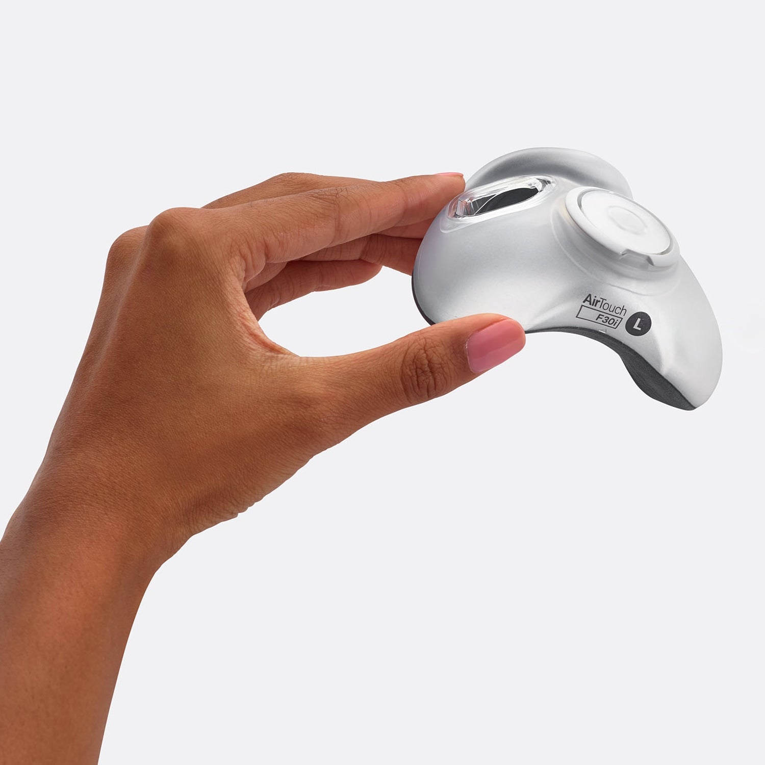 Hand holding a silver and white AirTouch cushion on a white background