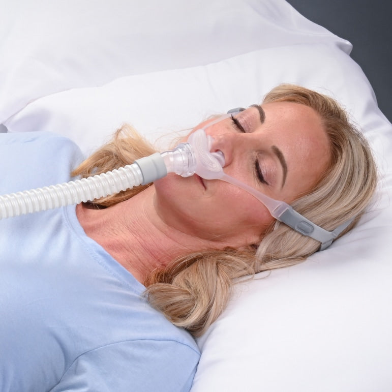 Woman using a CPAP machine while sleeping in bed