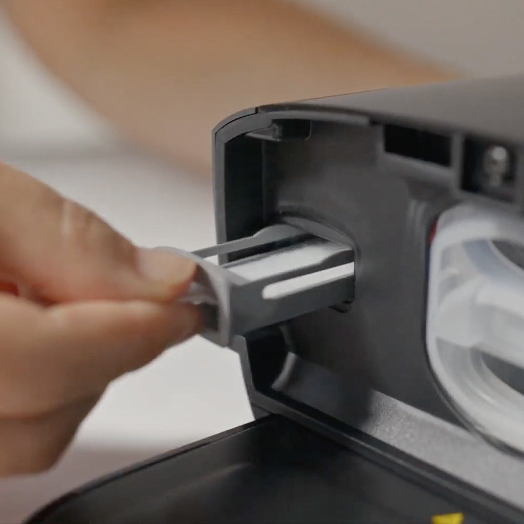 Fingers inserting Filter into Dreamstation 2 auto CPAP 