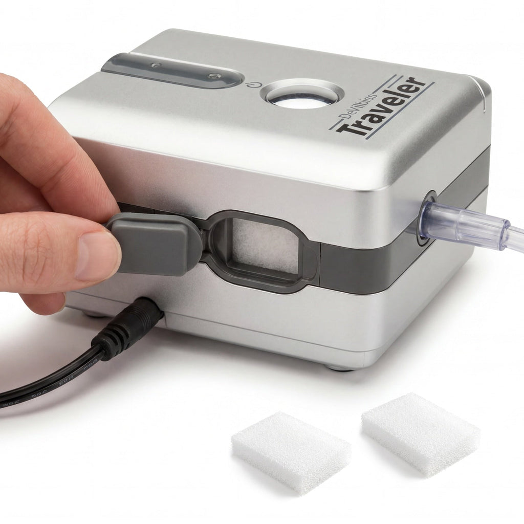 Hand holding a small electronic device labeled 'Traveler' with a cable connected on a white background.