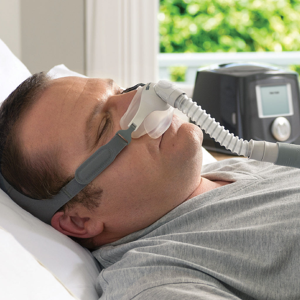 Man using a CPAP machine to sleep with a device on his face