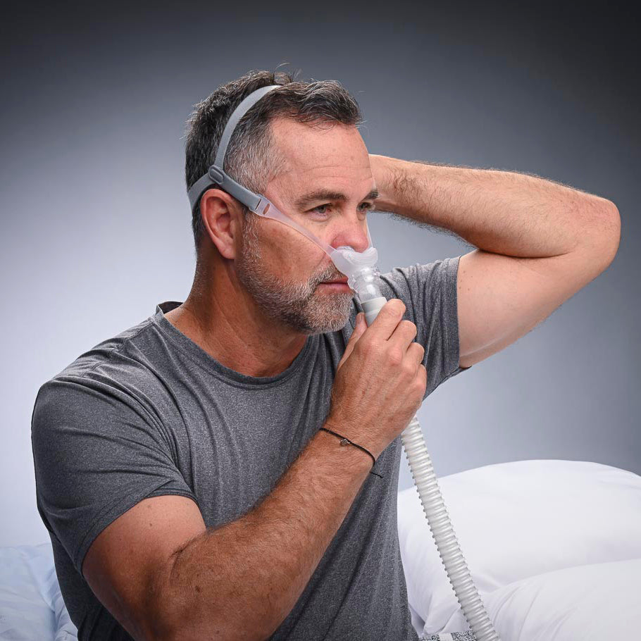 Man using a CPAP machine with a gray background