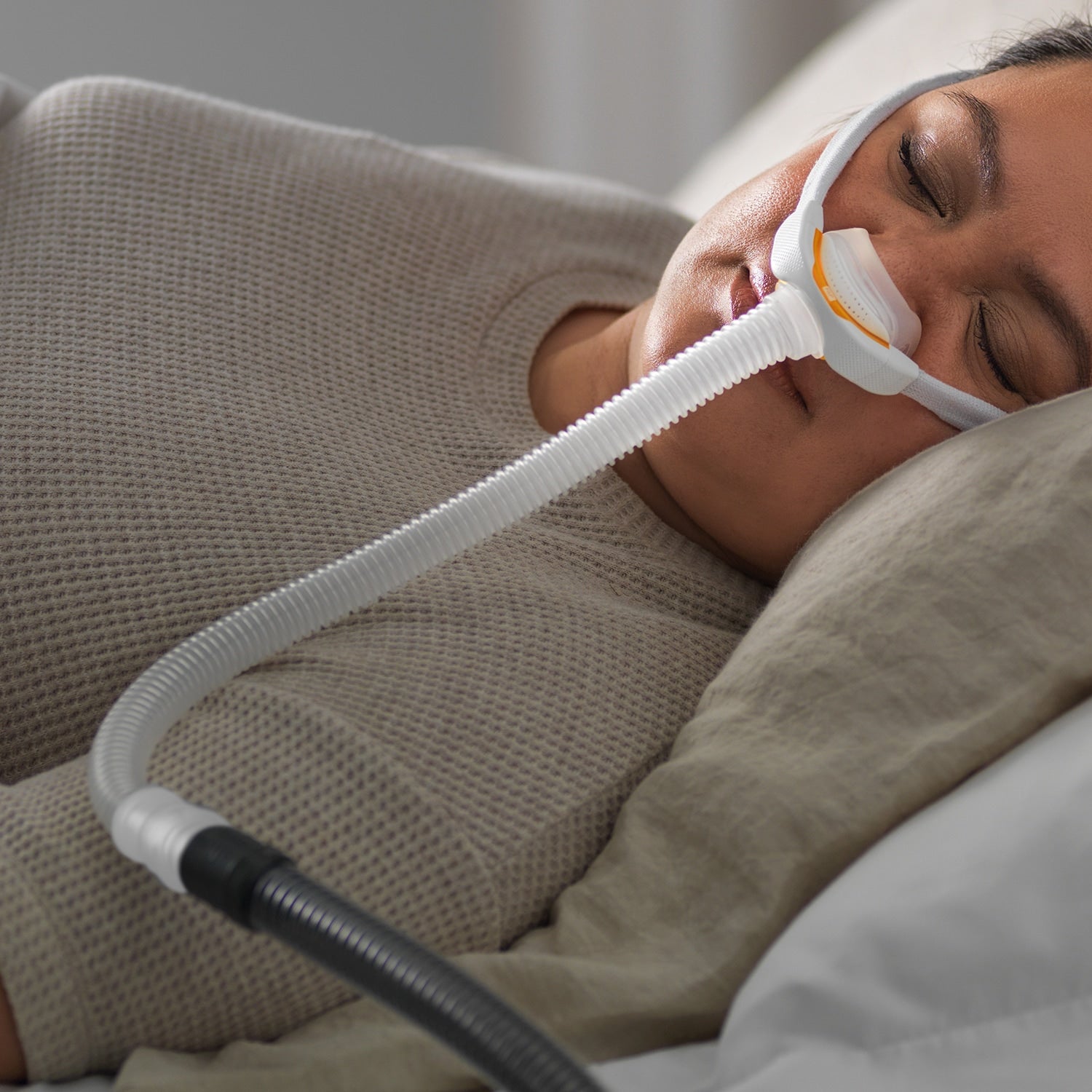 Person using a CPAP machine while sleeping in bed
