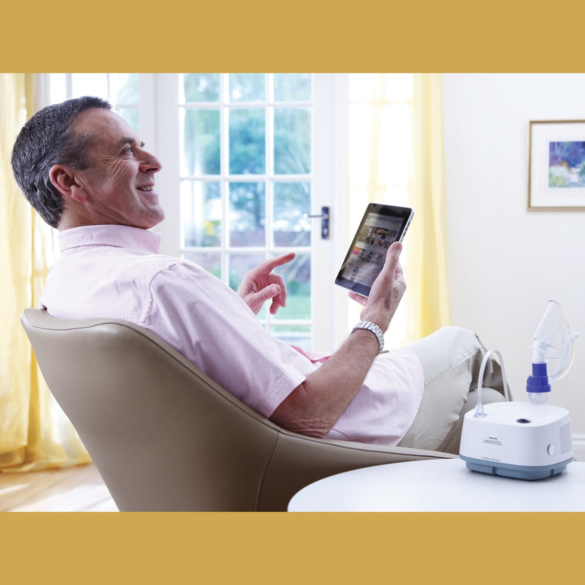 Man sitting in chair with an Inspire Essence Compressor on table next to him 