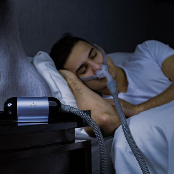 Man in Bed with Luna Travel CPAP Machine