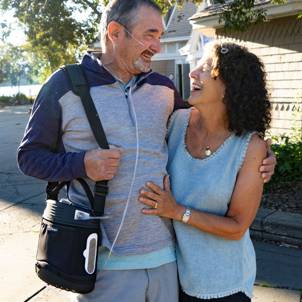 Man Hugging Woman while wearing Oxlife Liberty Portable Oxygen Concentrator 