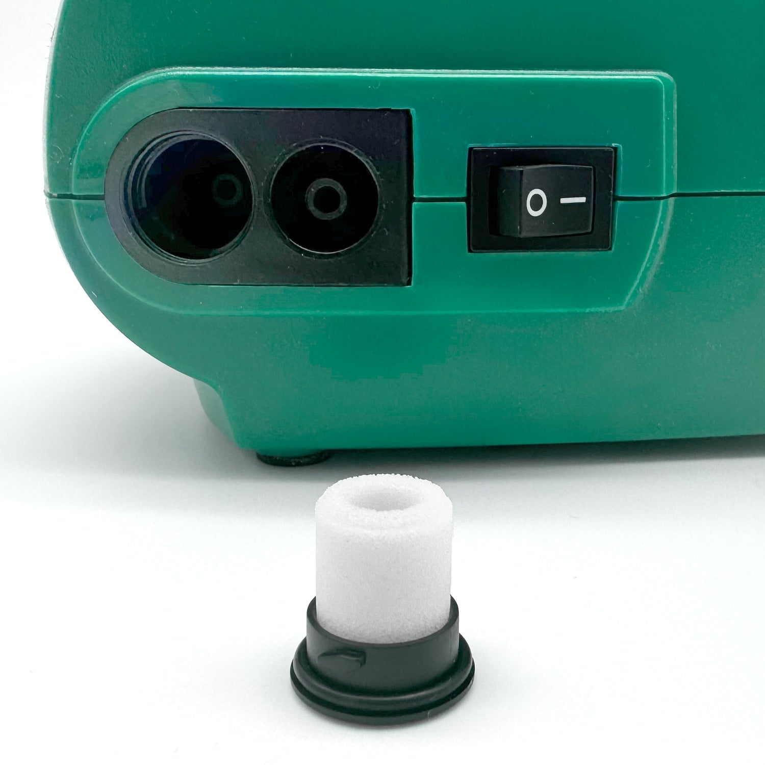 Green machine with black connectors and a white filter on a white background