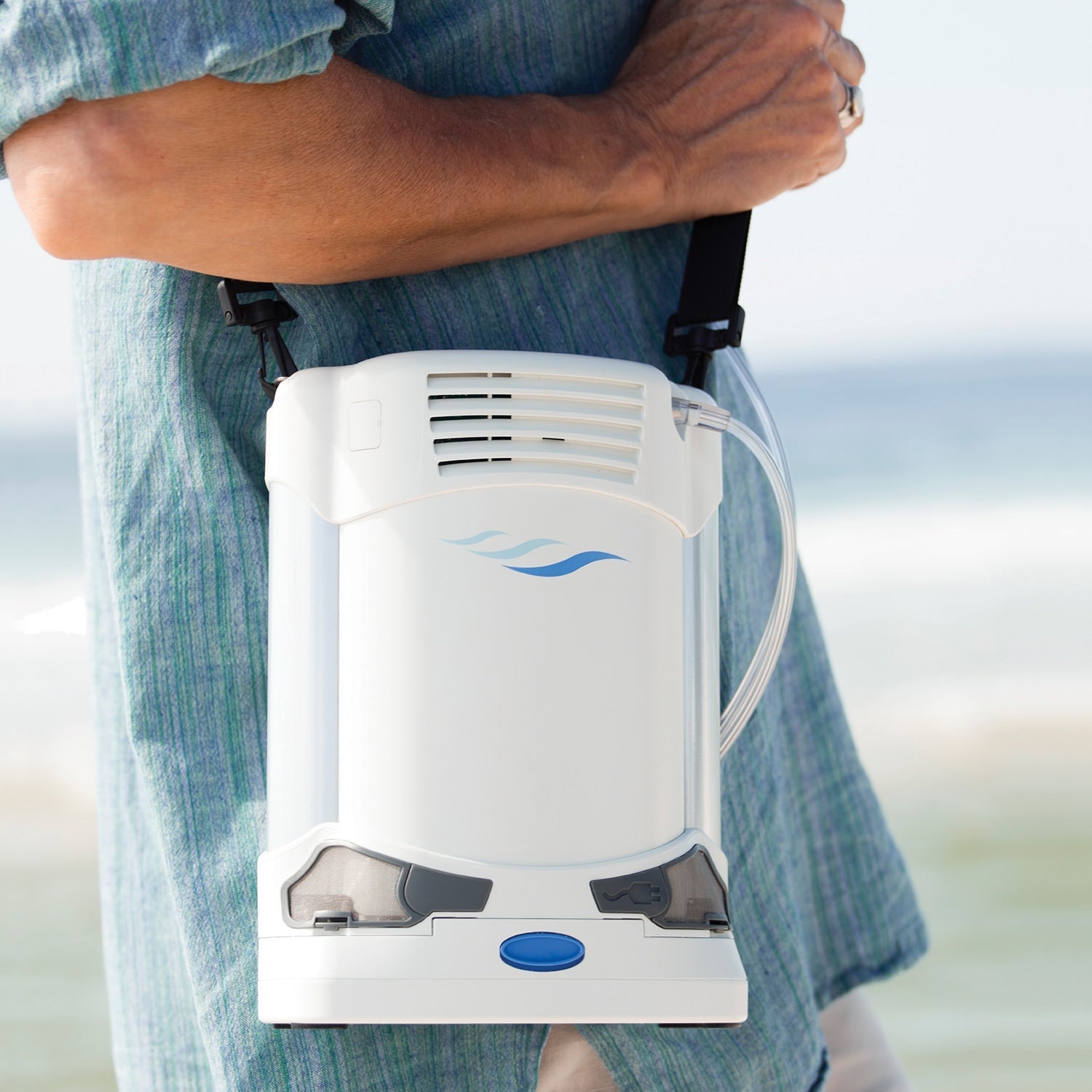 Portable oxygen concentrator held by a person with a blurred background