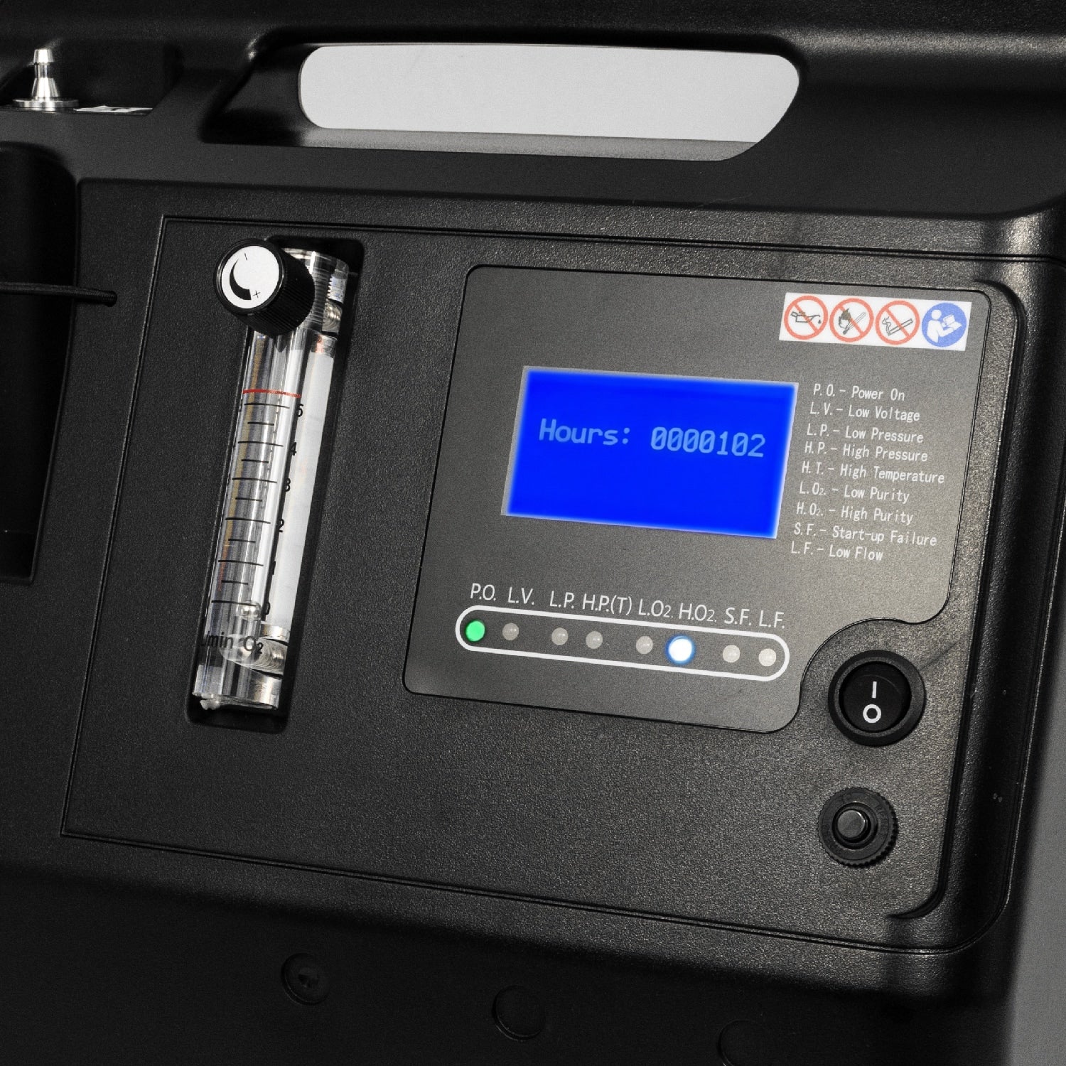 Close-up of a black medical oxygen delivery device control panel with a blue digital display showing hours, a flow meter, and control buttons.