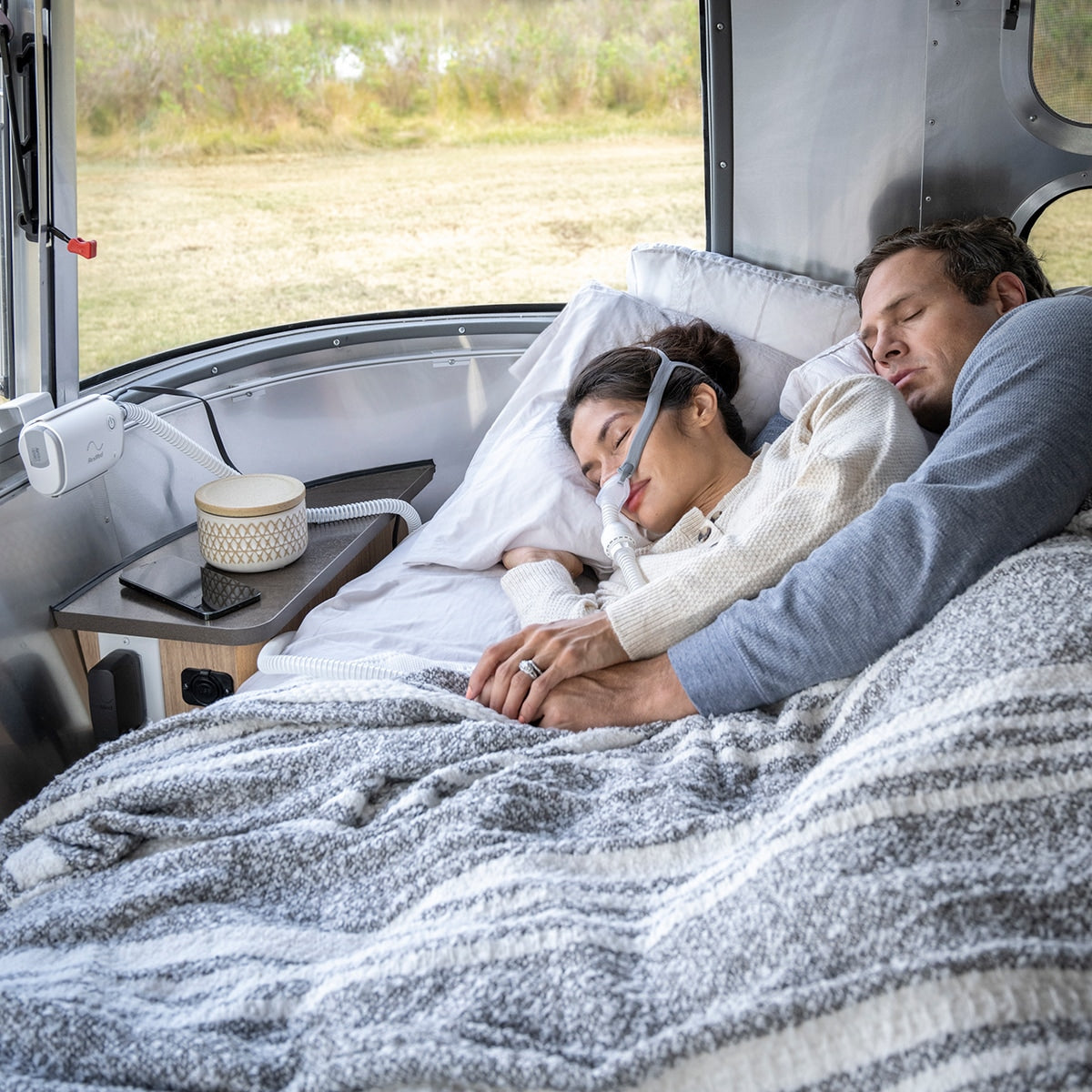 Women Sleeping with CPAP Mask on with an Airmini Auto CPAP Machine mounted to a wall in a camper 
