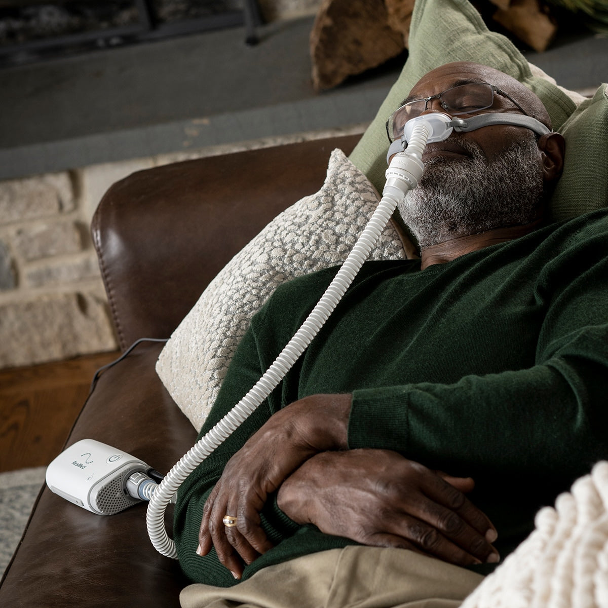 Man Sleeping on Sofa wearing a CPAP Mask while using an Airmini CPAP