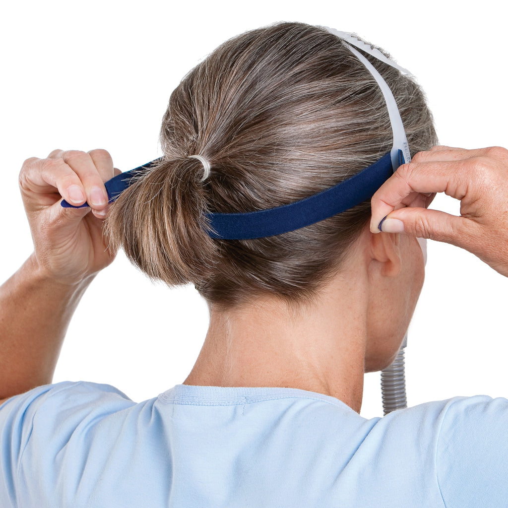 Person adjusting a blue headband with a white background