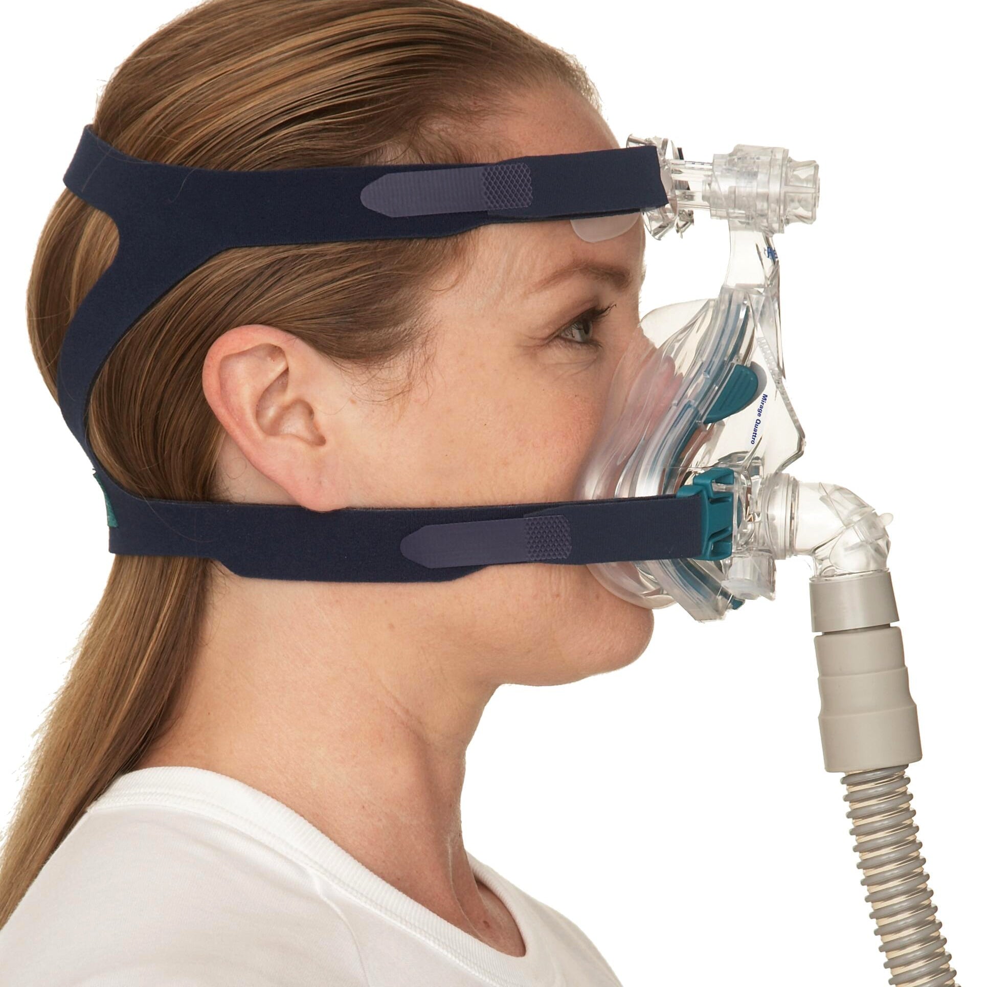 Person wearing a full-face CPAP mask with hose on a white background