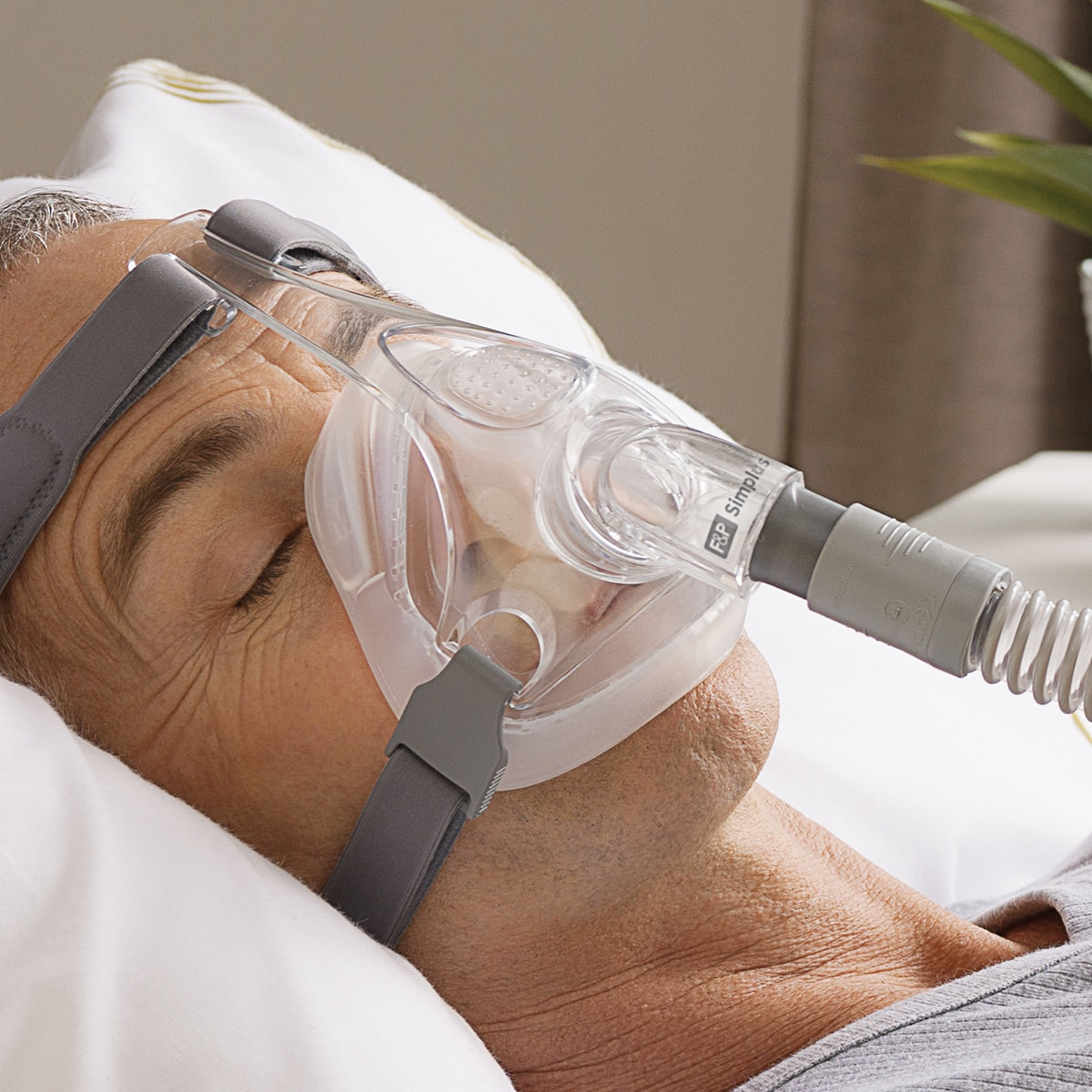 man wearing cpap mask in bed closeup