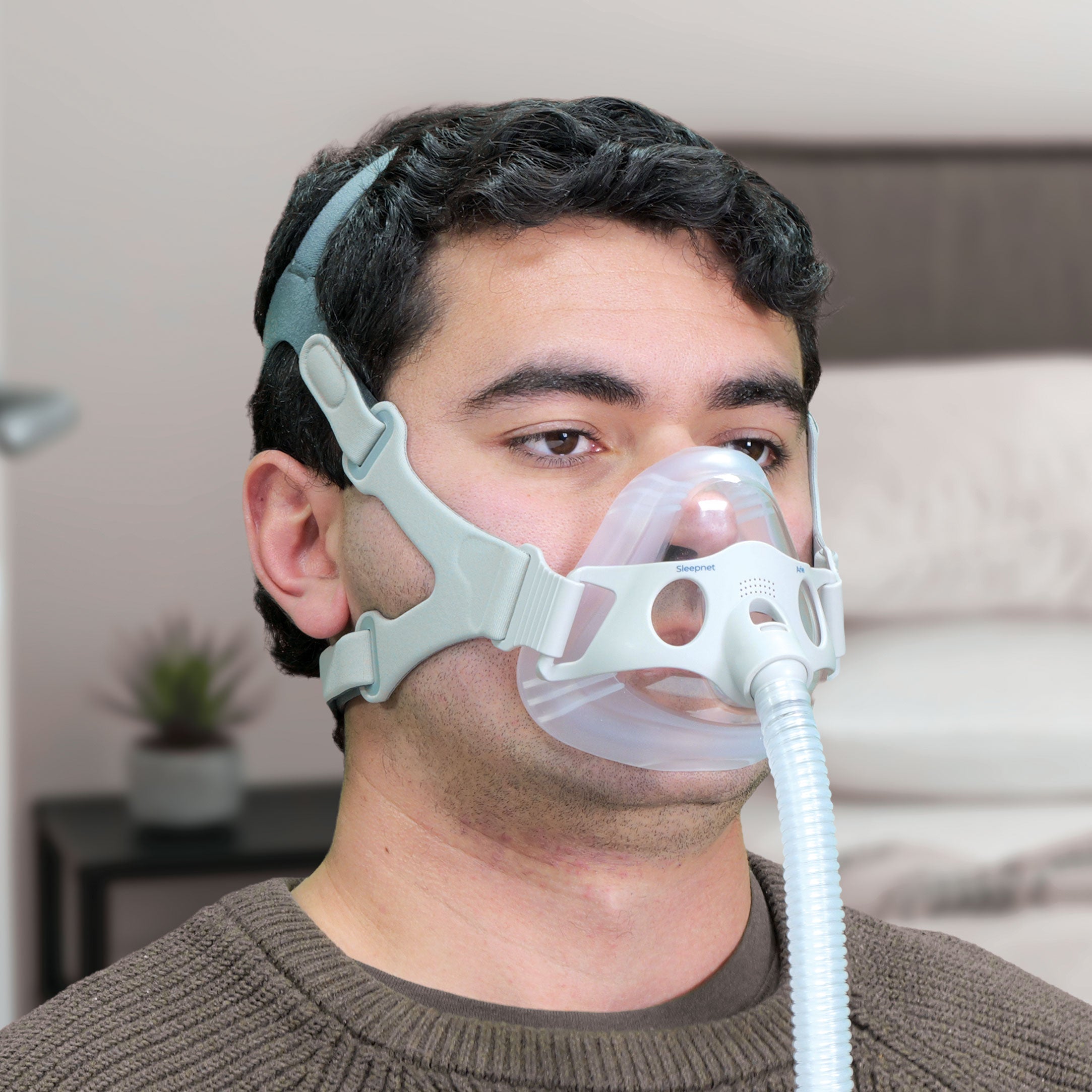 Man wearing a CPAP mask in a home setting