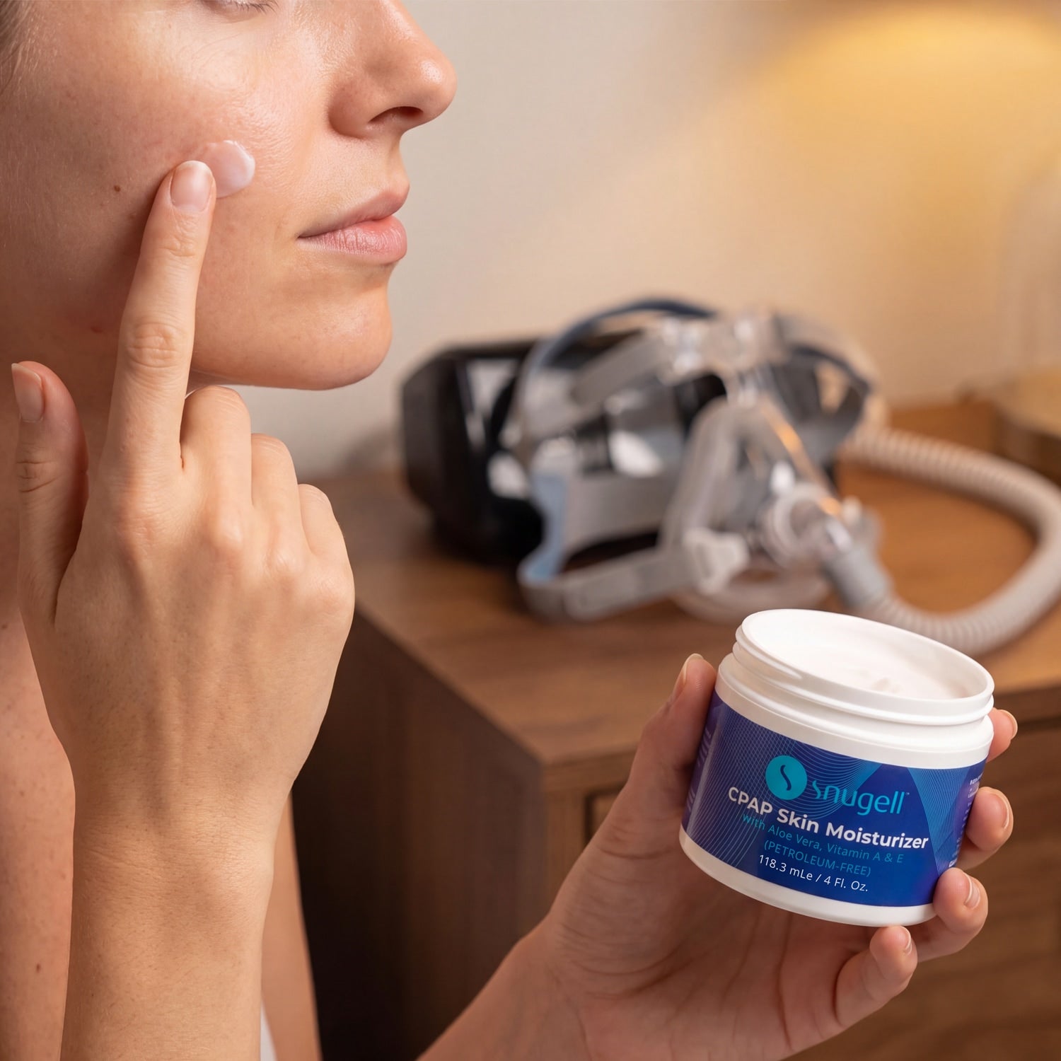 Woman holding a container of Snugell skin moisturizer for her while applying it to her face 