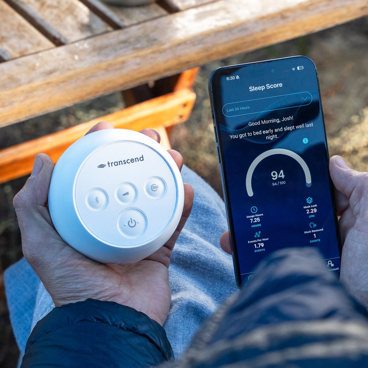 Man looking at his Sleep Score on his phone while holding a Transcend Micro CPAP