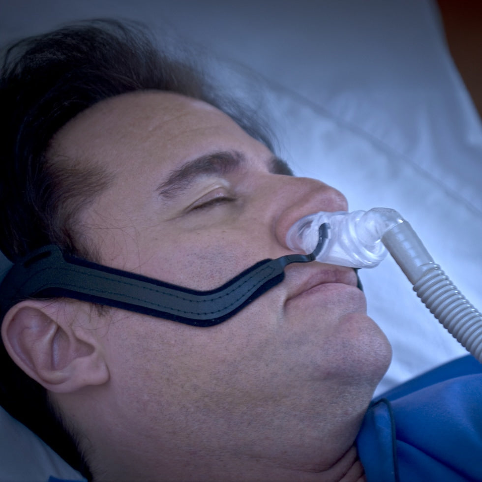 Person using a CPAP machine with an Aloha Nasal Pillow mask during sleep