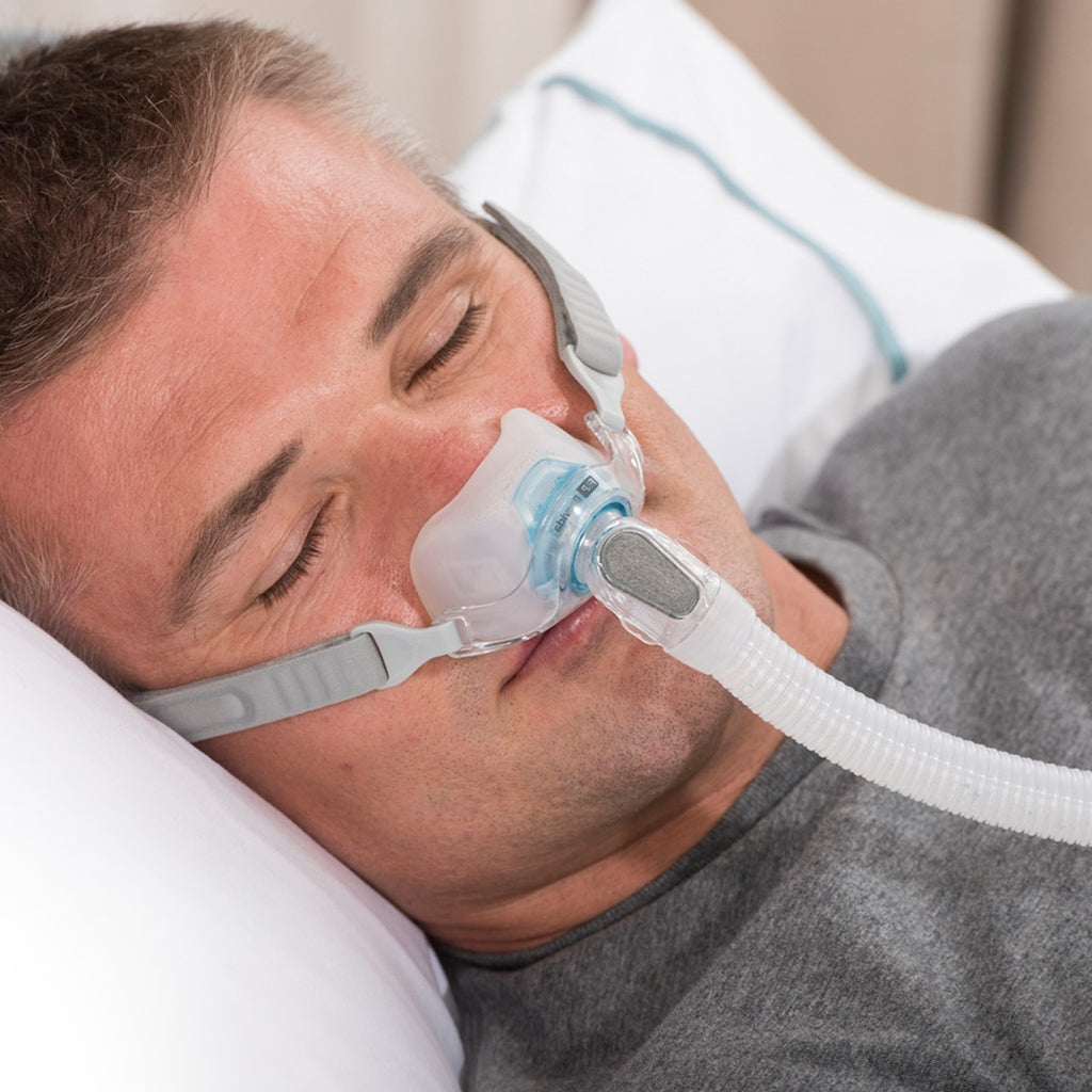 Man Sleeping while wearing a Brevida nasal pillow mask 