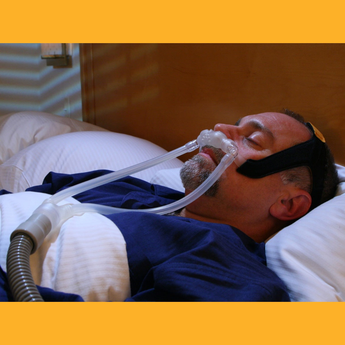 Man In Bed Wearing Bravo Nasal Pillow CPAP Mask 