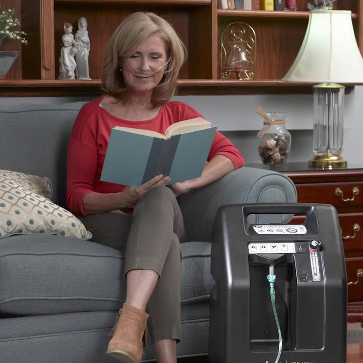 Woman reading while wearing Devilbiss 5 Oxygen Concentrator 