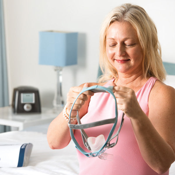 Woman putting on Eson 2 CPAP Mask