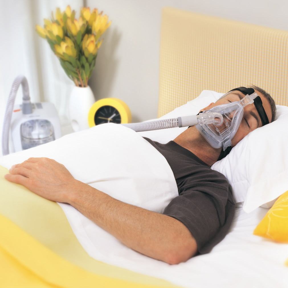Person sleeping with a  Flexifit 432 CPAP mask in a bedroom setting