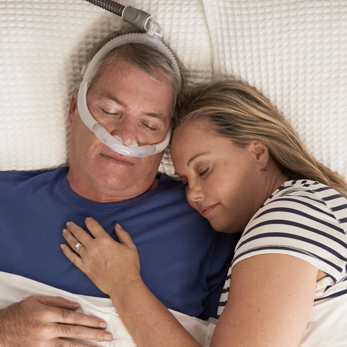 Man sleeping while wearing an Airlift P30i next to a woman