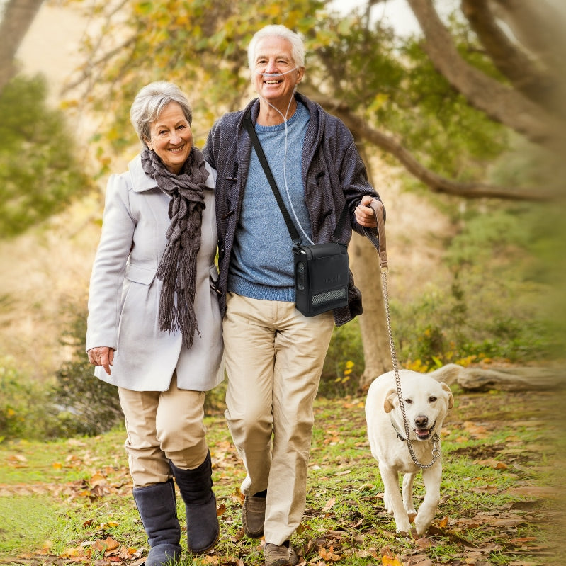 Man walking a dog while wearing an Inogen One G5 concentrator 