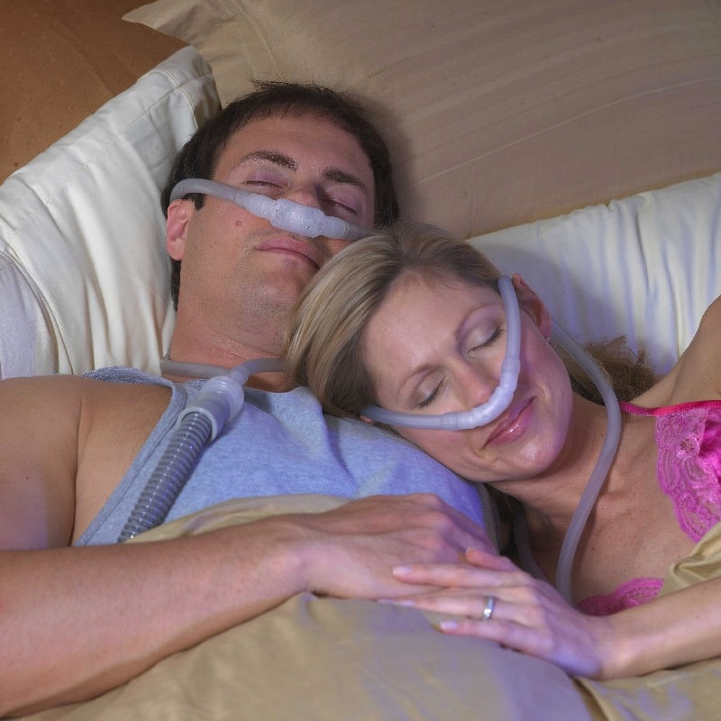 Men and Woman in Bed both wearing a Nasal -Aire II CPAP Mask 