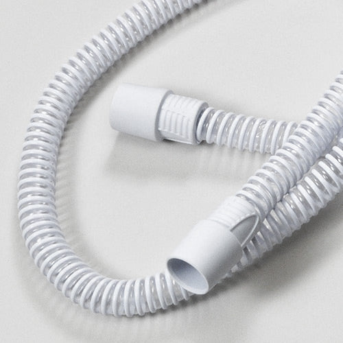 White flexible hose coiled on a light gray background