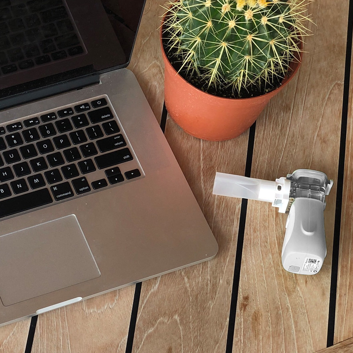 Sunset Mini Mesh Nebulizer on a desk with a computer and plant 